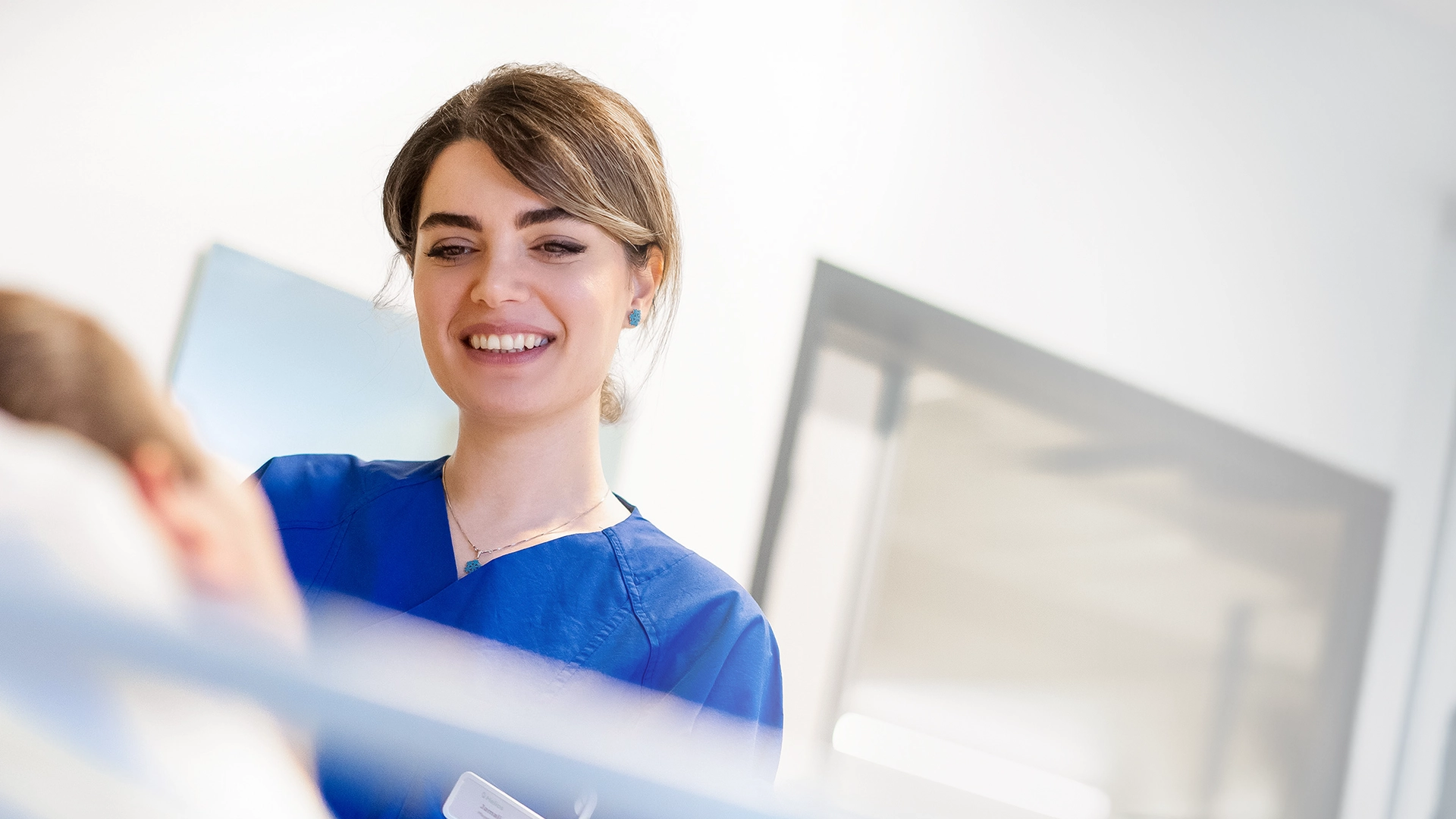 A hospital employee is smiling while talking to a patient (Photo)