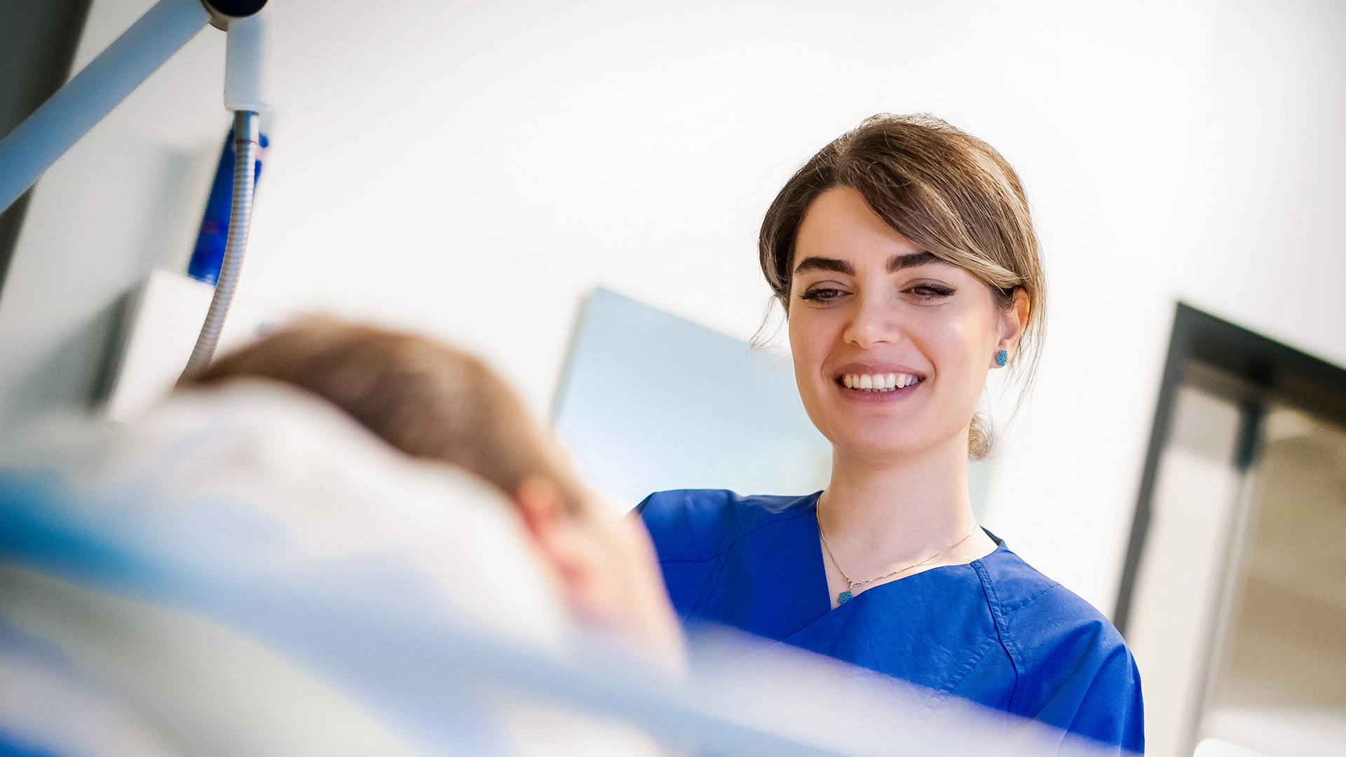 A hospital employee is smiling while talking to a patient (Photo)