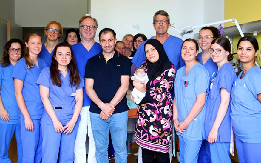 Gruppenbild des hochspezialisierten Teams des Helios Klinikums Pforzheim mit den Eltern und dem Frühgeborenen, das in der 26. Schwangerschaftswoche mit einem Geburtsgewicht von 490 Gramm zur Welt kam (Foto)