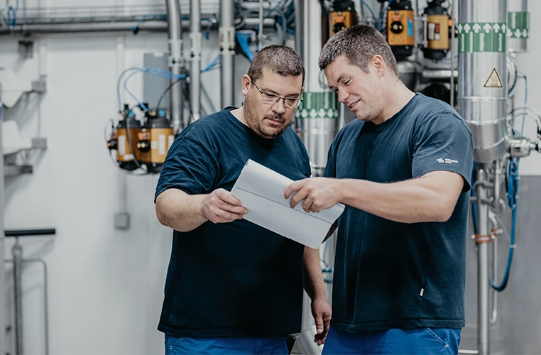 Dos empleados comentan un documento, tecnología al fondo (foto)