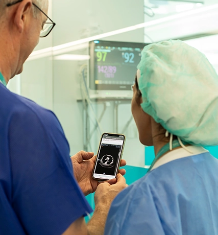 Personal médico observa conjuntamente un teléfono (foto)