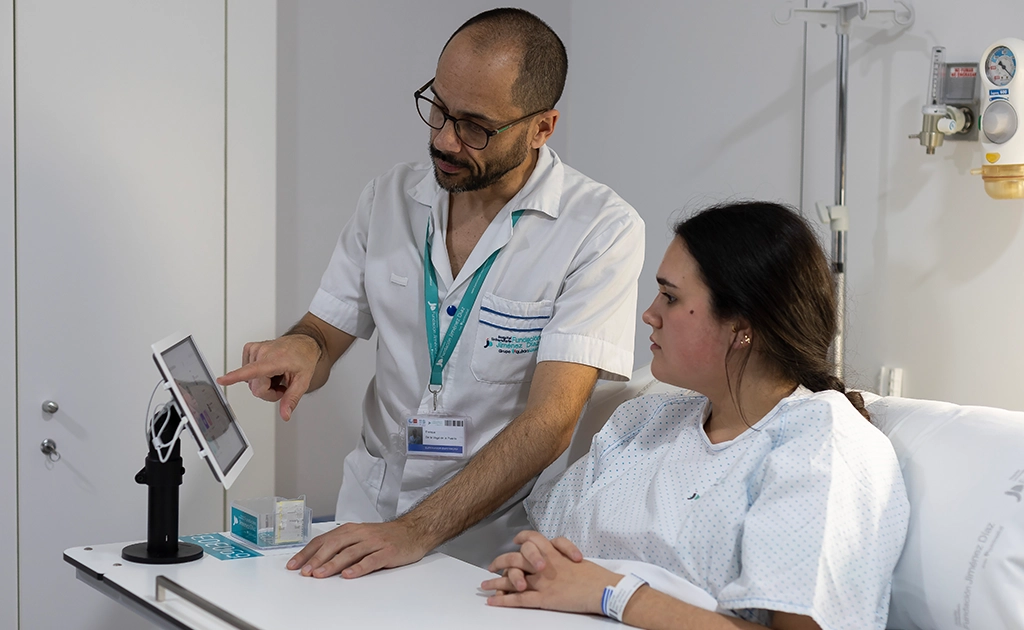 Paciente mira una tableta mientras el médico señala algo (foto)